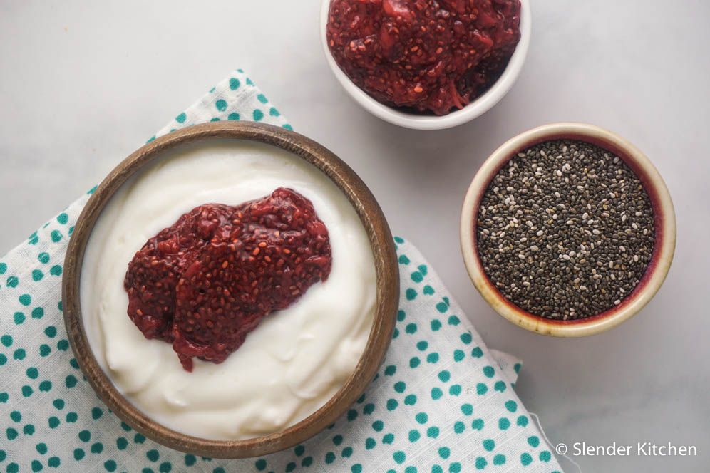 Strawberry chia seed jam on Greek yogurt in a wooden bowl.
