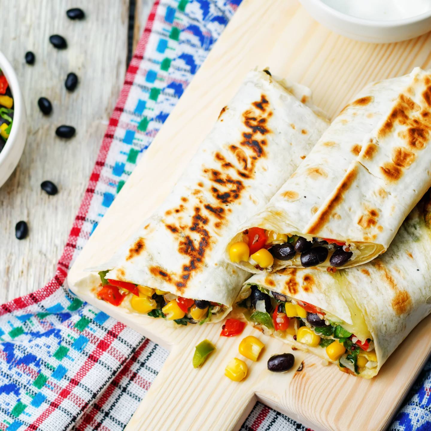 Homemade frozen burritos with beans, rice, and vegetables on a plate.