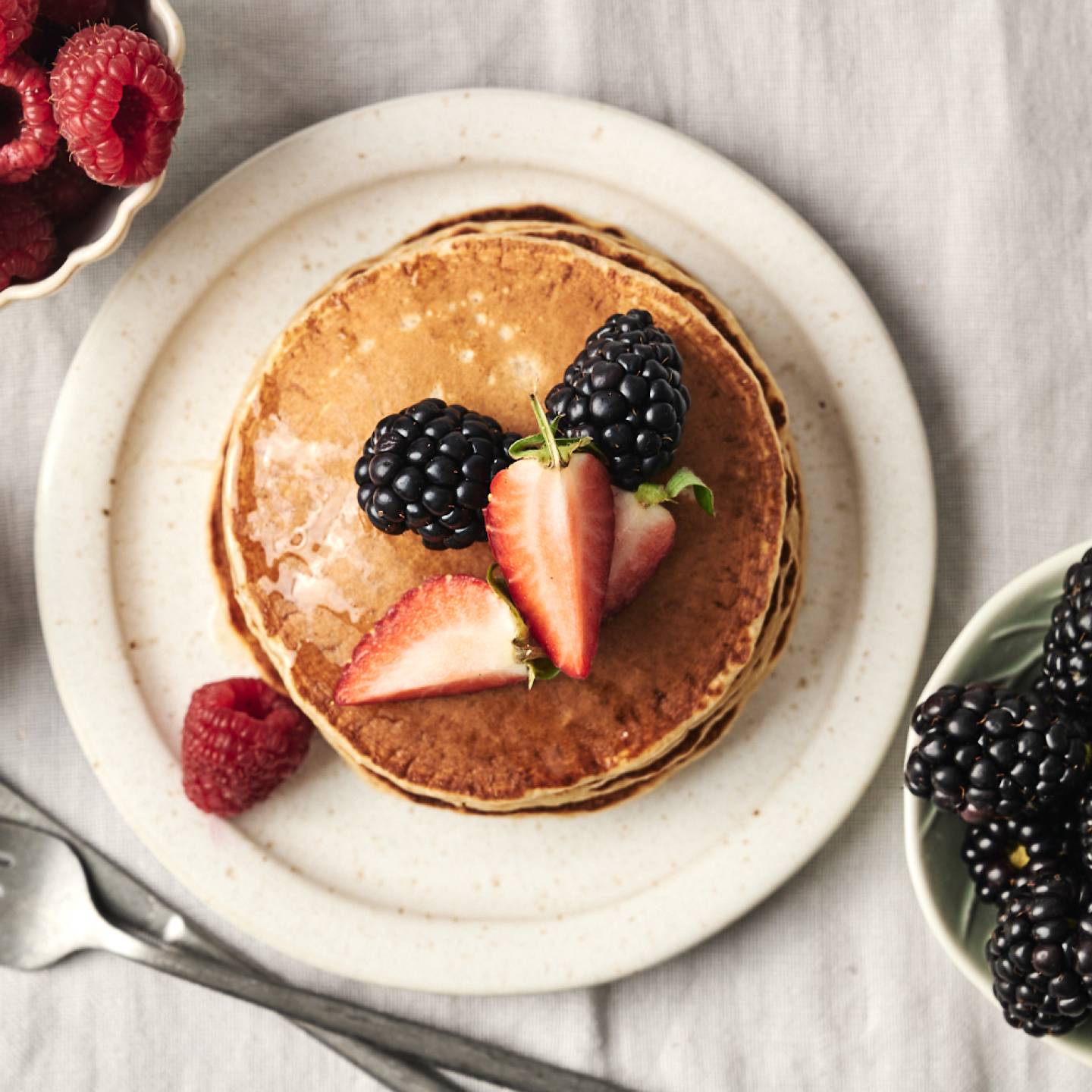 Fluffy protein pancakes topped with fresh berries.