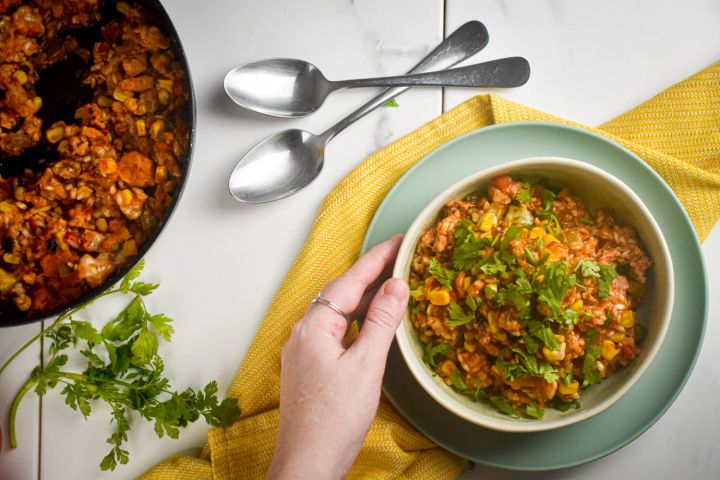 Turkey taco skillet with beans, corn, ground turkey, and rice in a bowl with cilantro and green onions.