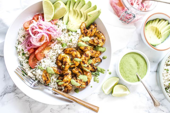 Peruvian shrimp rice bowls with grilled shrimp, white rice, cilantro mint sauce, salsa criolla, and sliced avocado.