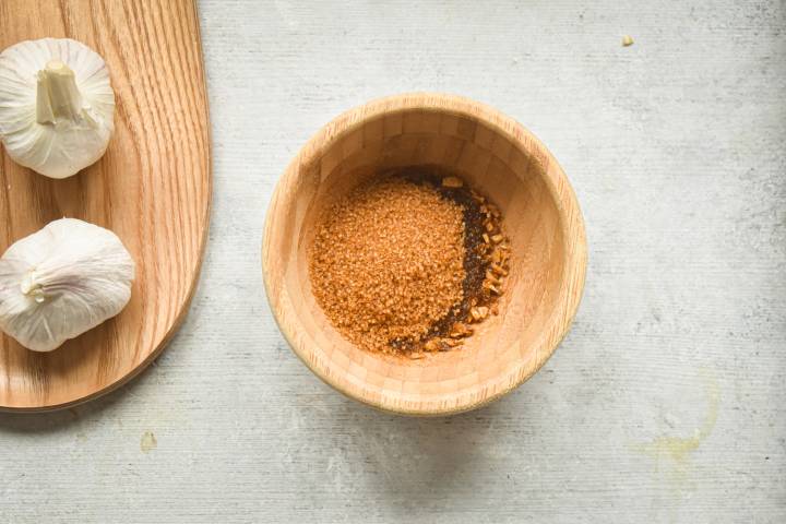 Brown sugar, garlic, and melted butter in a small wooden bowl.