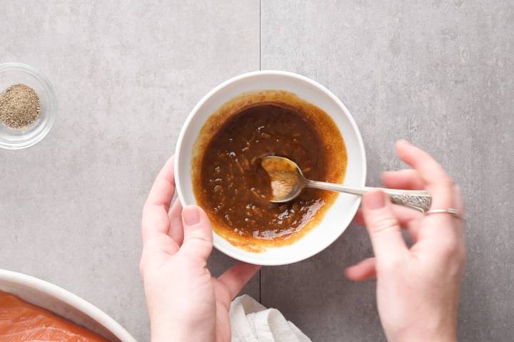 Brown sugar glaze with ginger being stirred in a bowl.