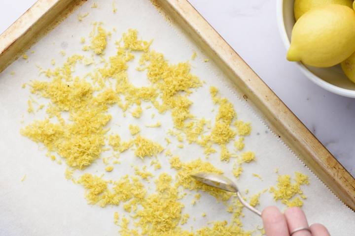 Lemon zest spread put on a baking sheet with parchment paper.