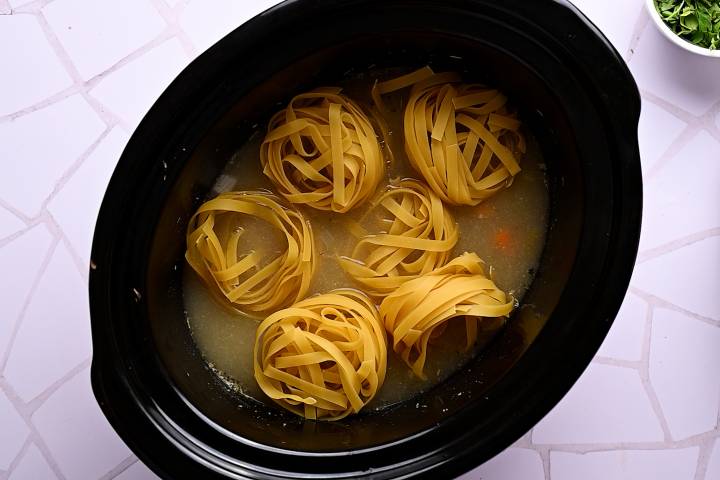 Egg noodles in turkey broth in a slow cooker.