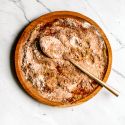 Fajita seasoning with chili powder, paprika, garlic powder, onion powder, and cumin mixed on a wooden plate.