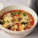 A bowl of lasagna soup with a rich tomato broth, ground meat, zucchini, and lasagna noodles, topped with parmesan cheese and fresh parsley.