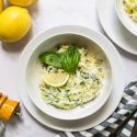 Creamy ricotta zucchini noodles with creamy cheese sauce, lemon, and basil leaves.