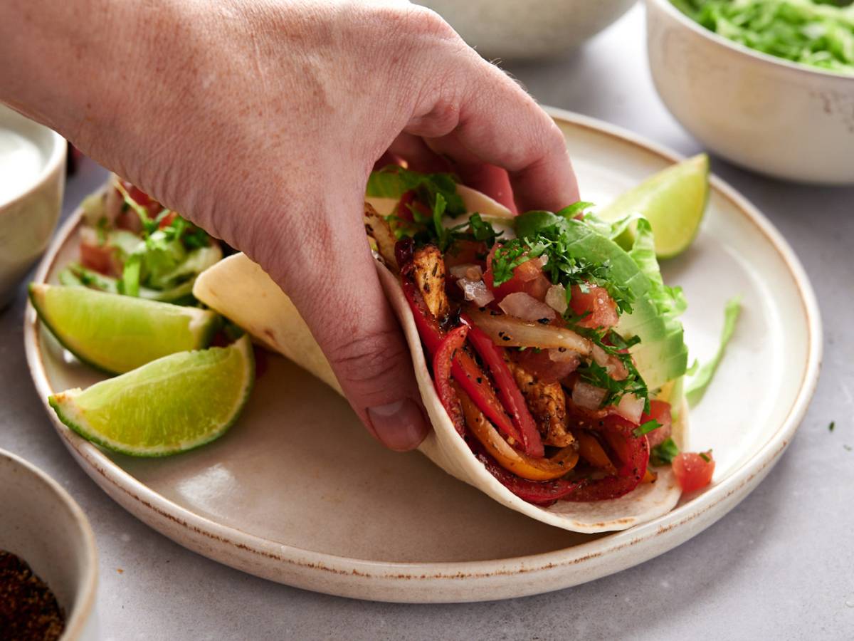 Fajita soft taco with chicken breast, peppers, onions, sour cream, avocado, and salsa
