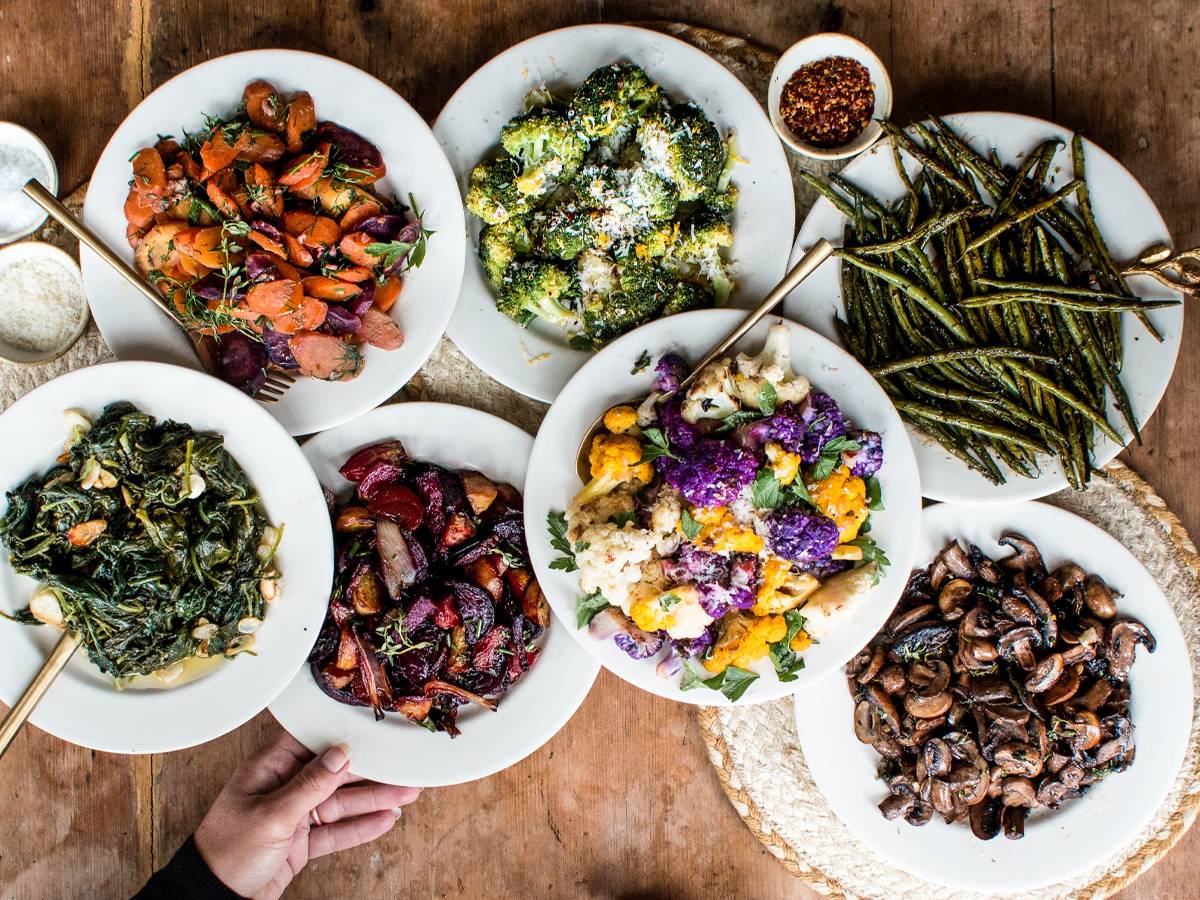 Roasted vegetables including broccoli, cauliflower, mushrooms, beets, and Bok choy on a wooden table.